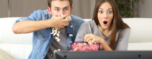 Man and woman watching a reality TV show.