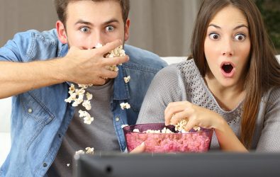 Man and woman watching a reality TV show.