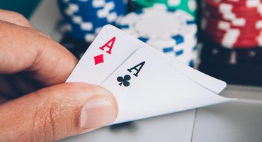 A hand holding two aces