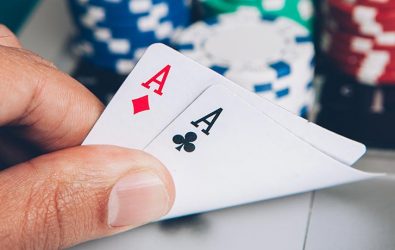 A hand holding two aces